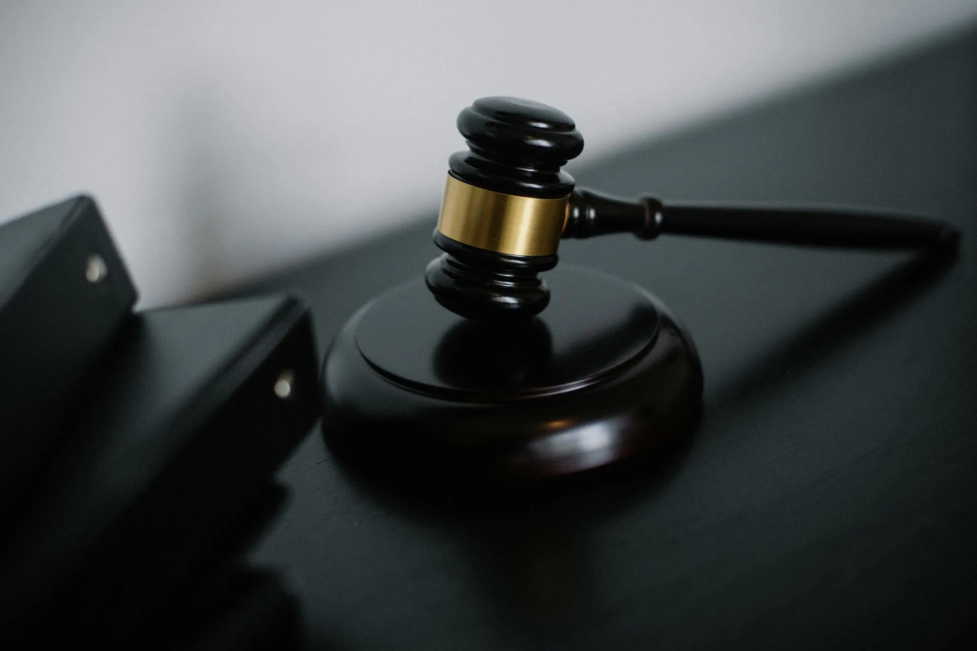 A judge's gavel resting on its block beside legal binders
