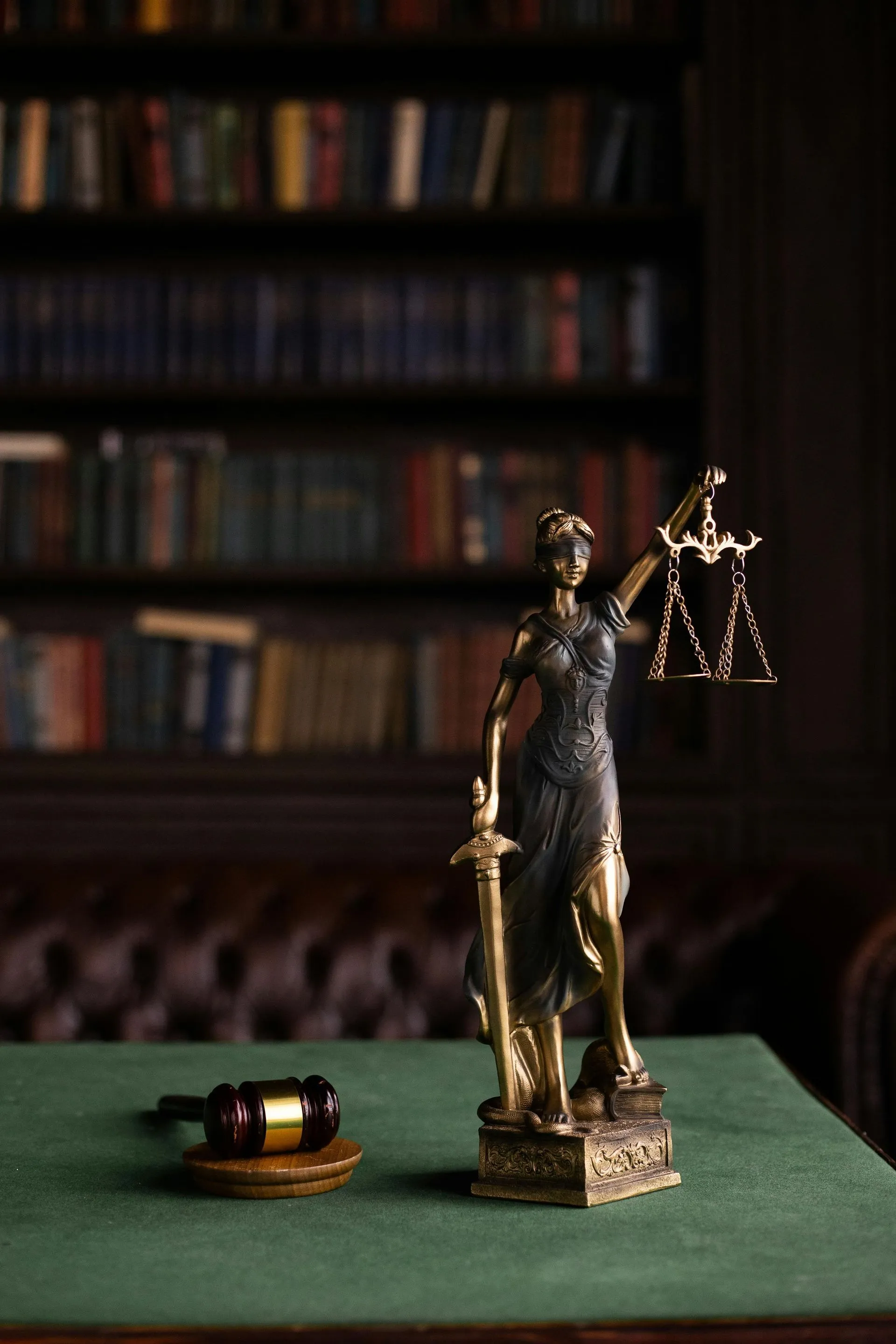 A Lady Justice statue and gavel on a desk